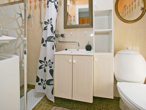 W łazience znajduje się umywalka, toaleta i lustro. w obiekcie Holiday home Tranekær IX w mieście Tranekær