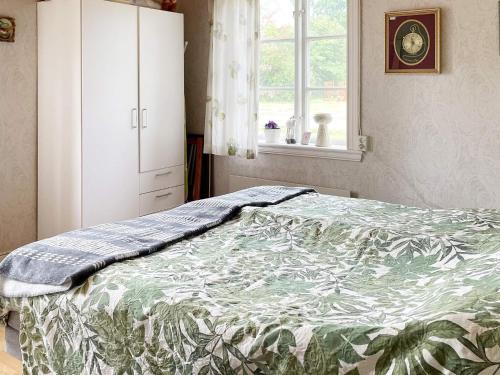 a bedroom with a bed and a cabinet and a window at Holiday home Lekeryd II in Lekeryd