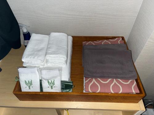 a wooden tray with towels and other items on a table at Spa and Esthetique Suichokan-Female&Adult Only in Jozankei
