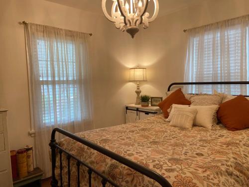 1 dormitorio con 1 cama con lámpara de araña y ventanas en We put the ‘Fun’ in your stay!, en Walla Walla