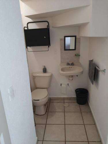 Baño pequeño con aseo y lavamanos en Cómoda Habitación en fraccionamiento privado, en León