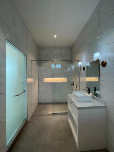 a bathroom with a sink and a glass shower at Dz Residence Tunjong in Kota Bharu