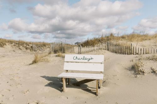 a bench sitting in the sand on a beach at The Roundtree, Amagansett in Amagansett