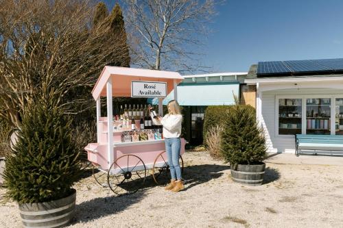 a woman standing in front of a pink ice cream stand at The Roundtree, Amagansett in Amagansett