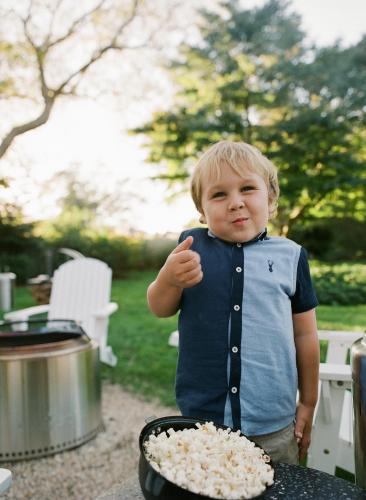 a young boy standing next to a bowl of popcorn at The Roundtree, Amagansett in Amagansett