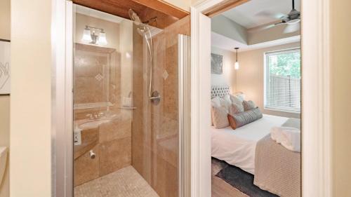 a bathroom with a walk in shower next to a bed at Perfect Stay High Ceilings Huge Yard And Amenities in Birmingham