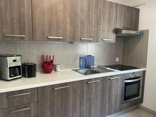 La cuisine est équipée de placards en bois, d'un évier et d'un four micro-ondes. dans l'établissement Studio moderne à 50m de la plage, climatisé, proche commerces et gare, parking disponible - FR-1-466A-50, à Saint-Raphaël