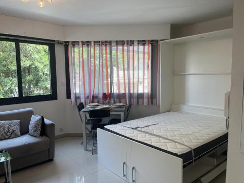 une chambre avec un lit, un canapé et une table dans l'établissement Studio moderne à 50m de la plage, climatisé, proche commerces et gare, parking disponible - FR-1-466A-50, à Saint-Raphaël