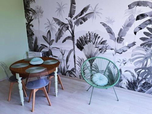 une salle à manger avec une table et deux chaises dans l'établissement Appartement avec Terrasse et Parking Privatif, Proche Commerces - FR-1-675-28, à Wimereux