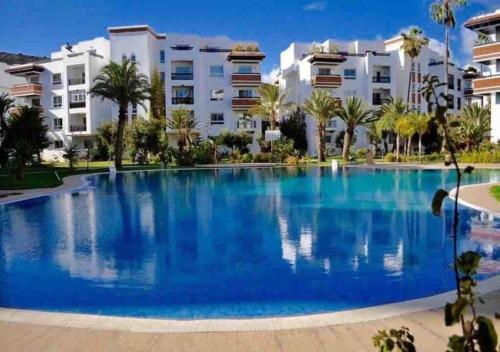 una grande piscina di fronte a un edificio di Luxueux appartement à la Marina d’agadir ad Agadir