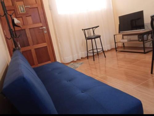 uma sala de estar com um sofá azul e uma cadeira em Paiva em Lima