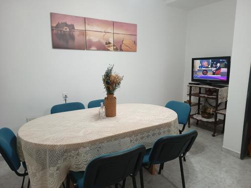 una sala da pranzo con tavolo, sedie e TV di Departamentos Güemes a Chilecito