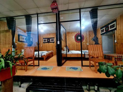 a room with two beds and two chairs and a table at Bac Ha Boutique Homestay in Bắc Hà