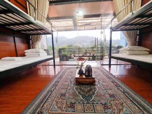 a room with two beds and a rug on the floor at Bac Ha Boutique Homestay in Bắc Hà
