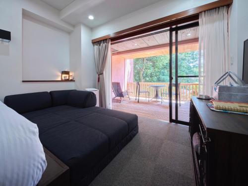 伊東市にあるドギーズ伊豆城ヶ崎のベッドルーム1室(ベッド1台付)、スライド式ガラスドアが備わります。