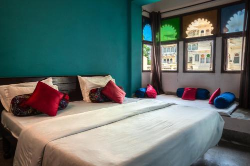 a bedroom with two beds with colorful pillows on them at Dreamyard Udaipur in Udaipur