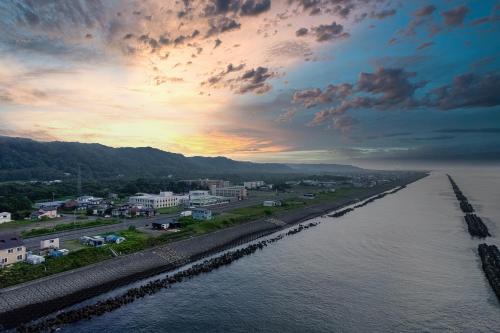 a view of a city and a river at sunset at The OCEAN VISTA in Shiraoi
