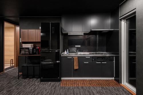a kitchen with black appliances and black cabinets at The OCEAN VISTA in Shiraoi