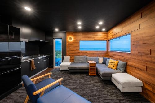 a living room with two couches and a kitchen at The OCEAN VISTA in Shiraoi