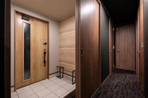 a hallway with wooden doors and a tile floor at The OCEAN VISTA in Shiraoi
