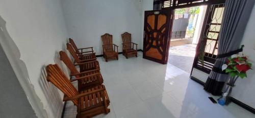 a group of chairs in a hallway with a door at Nilaveli Guest House in Nilaveli