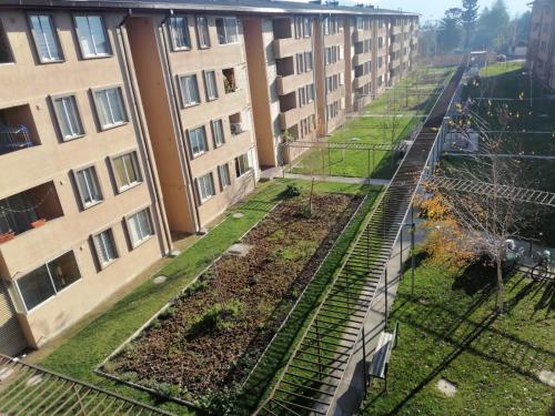 um complexo de apartamentos com um jardim no meio de um edifício em Departamento Condominio Magisterio em Talca