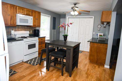 una cocina con una mesa con un jarrón de flores. en 5 Star with Direct Access to Brimstone Recreation Game Room Comfortable Up to 4 Bedrooms Stylish, en Huntsville