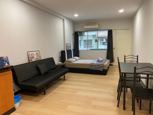 a living room with a bed and a couch and a table at KK City Api Api Apartment beside Centre Point by JR Homestay in Kota Kinabalu