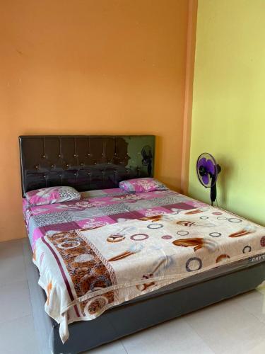 a bedroom with a bed with a blanket on it at Pondok Evsi in Senaru