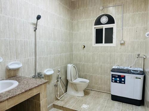 a bathroom with a toilet and a sink at البيت الأبيض للشقق المفروشة White House in Salalah