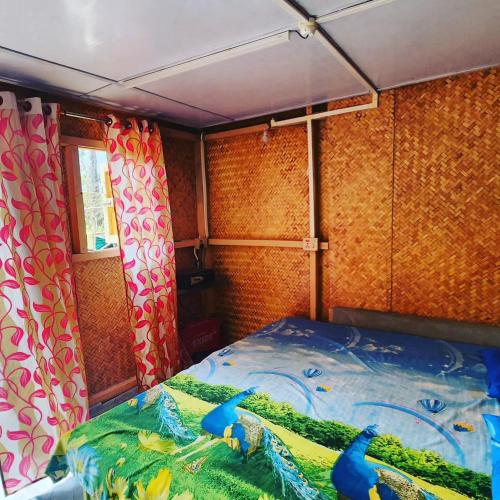 a small room with a bed in a trailer at Beyond Brahmaputra & Eagles Nest in Brahmakund
