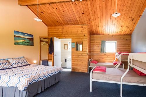 a bedroom with a bed and two bunk beds at Bay of Islands Lodge in Paihia
