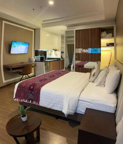 a hotel room with a large bed and a kitchen at Apartment Panbil with Gym & Pool #Unit 603 in Nagoya