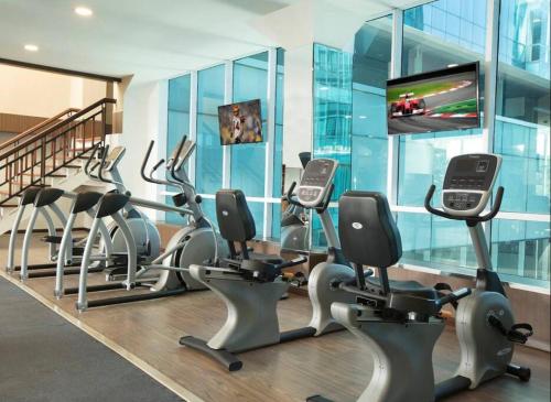 a gym with rows of exercise bikes and a flat screen tv at Panbil Residence Apartment Batam in Kangboi