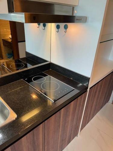 a kitchen with a stove and a counter top at Apartment Panbil with Gym & Pool #Unit 603 in Nagoya