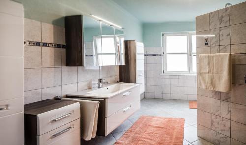 uma casa de banho com um lavatório e um espelho em Ferienwohnung Familie Hartinger em Riegersburg