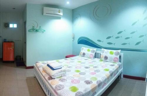 una camera da letto con un letto dipinto a muro con un pesce di Adrian View resort a Ko Si Chang