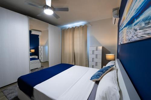 niebiesko-biała sypialnia z łóżkiem i wentylatorem sufitowym w obiekcie Preety Blue Residence villas w mieście Grand Baie