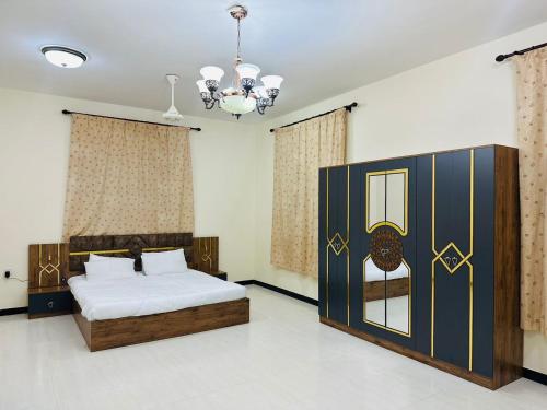 a bedroom with a bed and a chandelier at البيت الأبيض للشقق المفروشة White House in Salalah