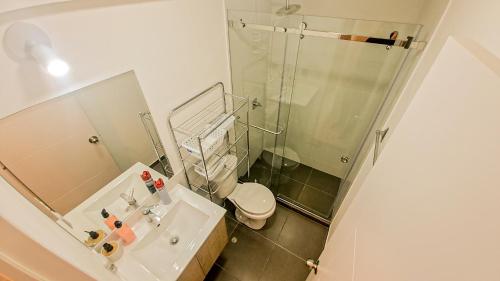a bathroom with a shower and a toilet and a sink at Exclusivo departamento piscina tempera vistamar in Lima