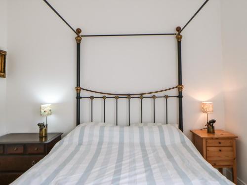 a bedroom with a bed and two night stands at Stable Cottage in Belford