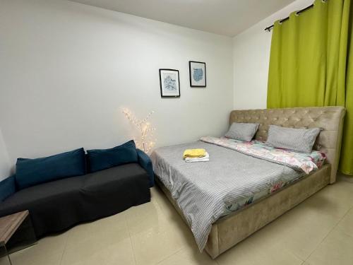 een slaapkamer met een bed en een bank bij Khalidiya Studio Villa 6 Room 13 Abu Dhabi UAE in Abu Dhabi