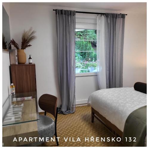 a bedroom with a bed and a window and a chair at Apartment Villa Hřensko 132 in Hřensko