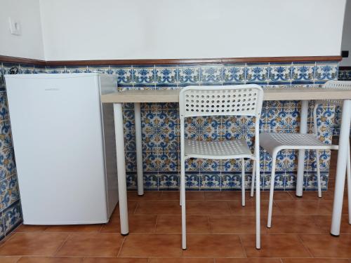 uma mesa e duas cadeiras numa cozinha em Rooms 10 mins walk from train station! em Agualva