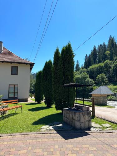a fire pit in a yard next to a house at Садиба "Джерело" in Yaremche