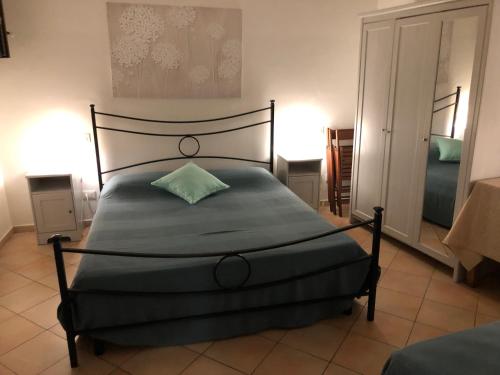 Un dormitorio con una cama con una almohada verde. en Il Cortile del Contadino, en Volastra