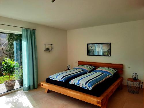 a bedroom with a bed with blue curtains and a window at Ferienappartement am Slevogtweg in Leinsweiler