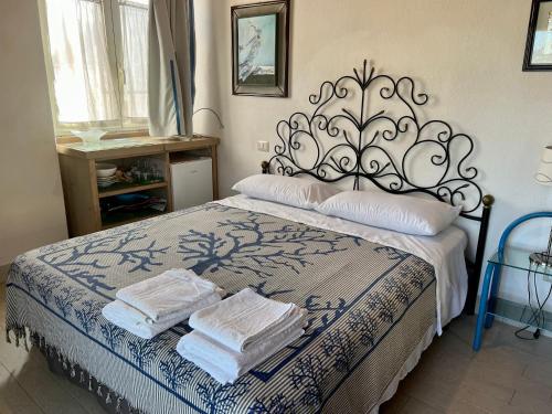 a bedroom with a bed with two towels on it at Stazzo La Foci soluzioni vista Mare in Aglientu