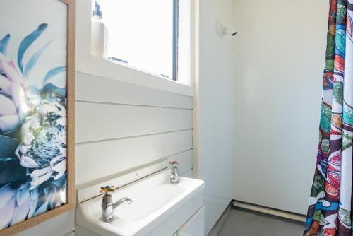 ein Bad mit einem Waschbecken und einem Fenster in der Unterkunft Bay of Islands Lodge in Paihia
