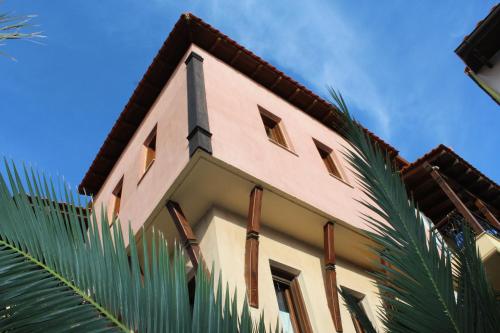 a building with a spire and a palm tree at Archodiko Toliadi Boutique Apartments and Suites in Ouranoupoli